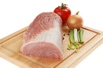Raw pork on cutting board and vegetables