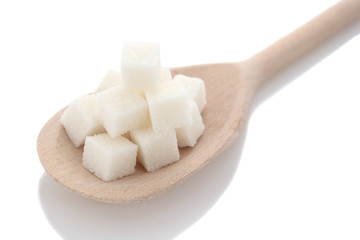 cubes of white sugar in a wooden spoon closeup
