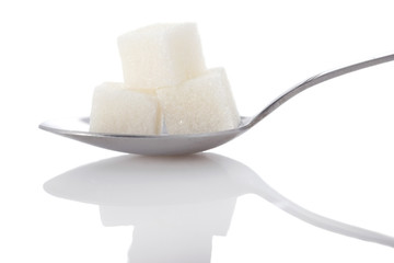 cubes of white sugar in a metal spoon closeup