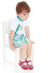 Little boy sitting on a chair.