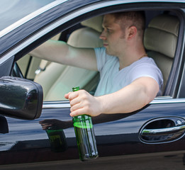 Driving Under the Influence. Man drinking alcohol in car.