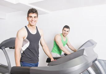 Fototapeta na wymiar Two guys on treadmill