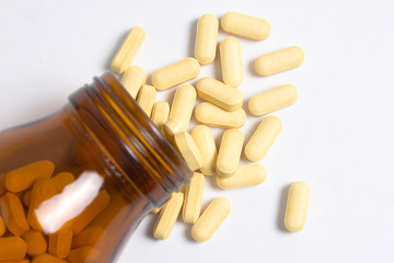 Prescription pill bottle spilling pills on to surface isolated o