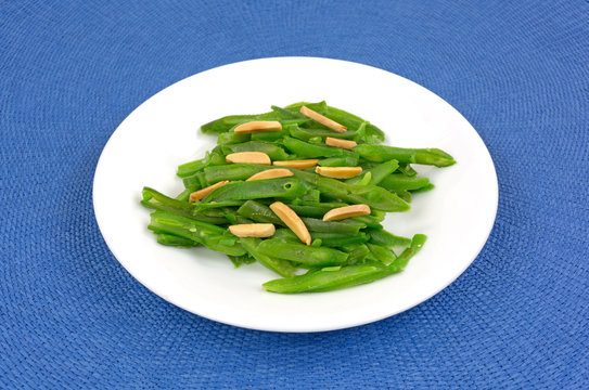 Green beans and sliced almonds on white plate