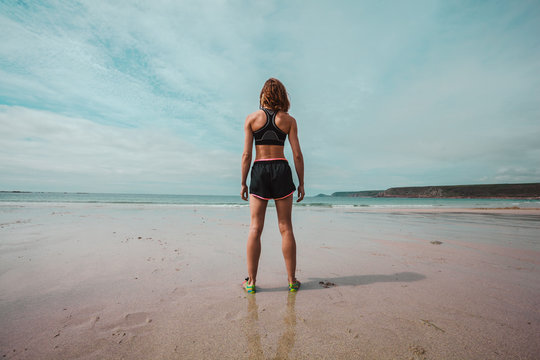 Young athletic woman standing on the beach