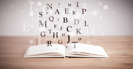 Opened book with flying letters
