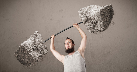 skinny guy lifting large rock stone weights