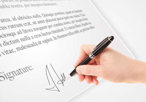 Hand writing personal signature on a paper form