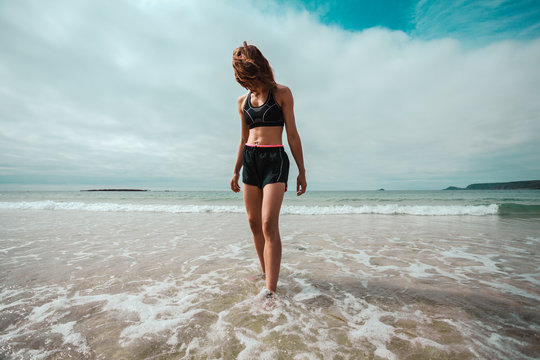 Athletic young woman walking on the beach