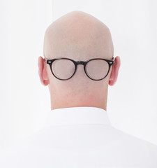 back of a bald head with glasses