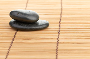Fototapeta na wymiar The spa a stone on bamboo background