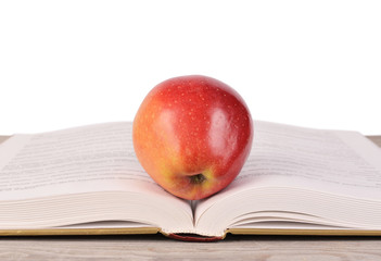 Book with apple isolated on white