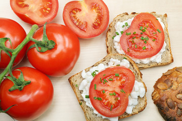 Sandwich with cottage cheese and tomato on wood background