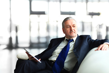 Portrait of a mature businessman with digital tablet