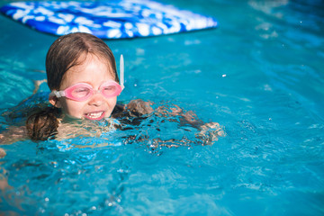 Little adorable girl enjoy in the swimming pool