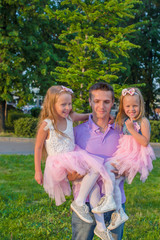 Naklejka premium Young Father and his adorable daughters having fun outdoors