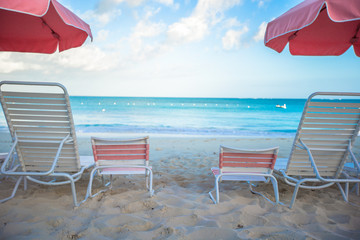 Beach lounges under an umbrella on white sand