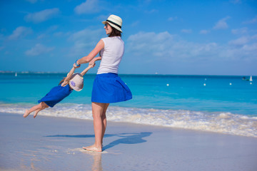 Young mom and adorable little daughter have fun at tropical