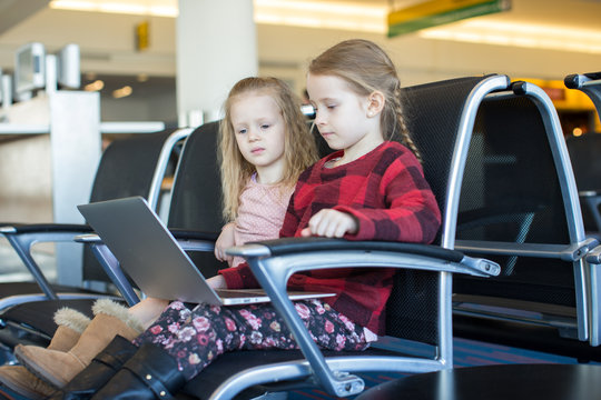 Kids with a laptop at the airport while waiting his flight