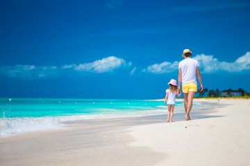 Happy father and his cute little daughter at beach
