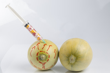 Melons and syringe with pills