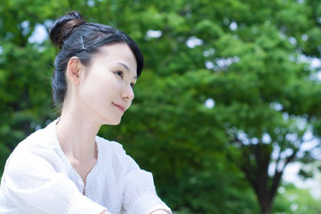 Fototapeta premium 緑を背景にして考える女性