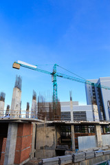 Building crane and construction site under blue sky
