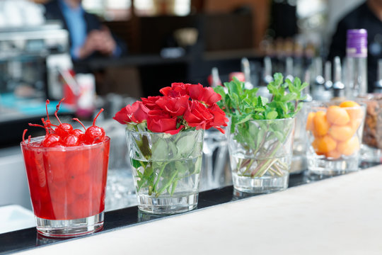Cocktail cherries, herba and flowers on bar counter