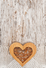 Wooden heart on the lace fabric and old wood