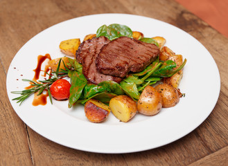 Steak with fried potatoes on table