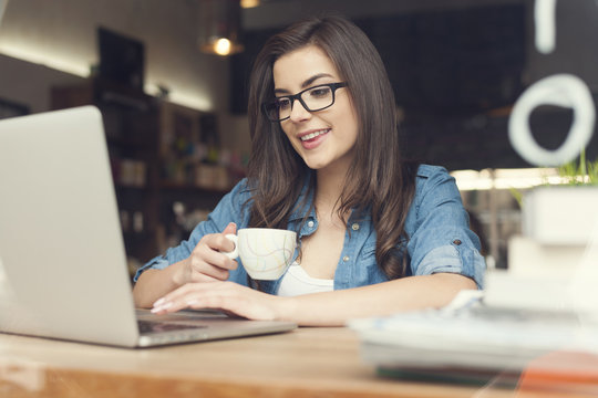 Beautiful Hipster Woman Using Laptop At Cafe