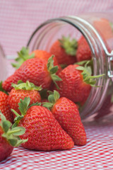 Tasty fresh strawberries in glass storage jar