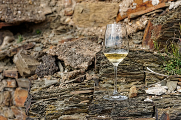 Glass of Riesling wine on slate rock - obrazy, fototapety, plakaty