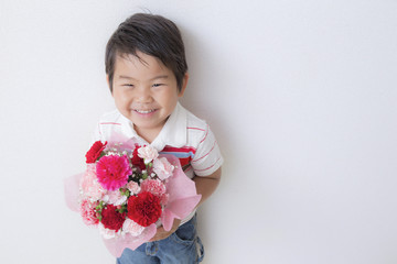 カーネーションの花束を持つ子供