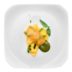 Ravioli with pesto sauce and potato chips in plate, isolated