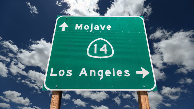 Mojave Desert Freeway Sign to Los Angeles with Time Lapse Clouds