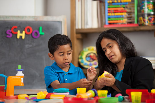 Hispanic Mom With Child In Home School Setting Working On Crafts