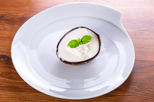 Coconut ice cream in coco shell on the plate