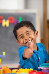 Happy Hispanic Child in School Setting Giving Thumb Up