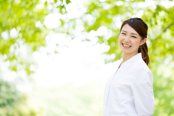 young asian doctor relaxing on green background