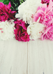 colorful peonies on white wooden surface