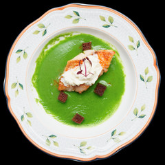 Seabass with herbs and spinach puree isolated on black