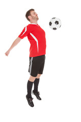 Fototapeta na wymiar Player Hitting Soccer Ball With Chest