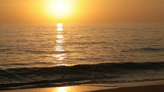golden sunrise over the sea with small waves