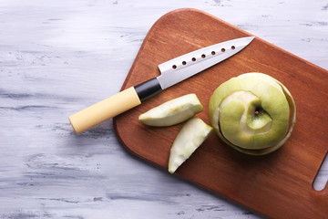 Kitchen knife and green apple,   on wooden background