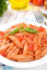 Pasta with tomato sauce on plate on table close-up