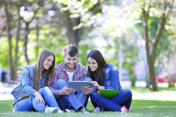 Happy students sitting in park