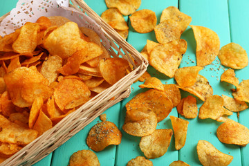 Homemade potato chips on color wooden table