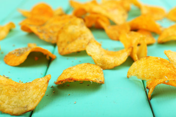 Homemade potato chips on color wooden table