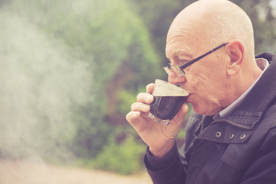 Senior man drinking in garden